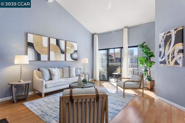 living room with high vaulted ceiling and light hardwood / wood-style floors