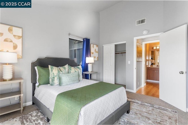 carpeted bedroom featuring a closet and a high ceiling