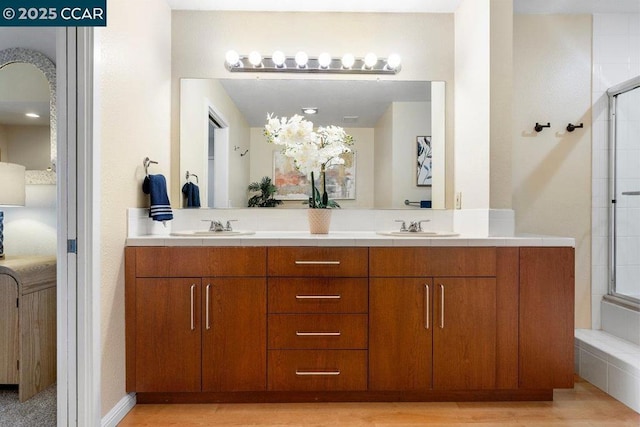 bathroom featuring hardwood / wood-style flooring, vanity, and an enclosed shower