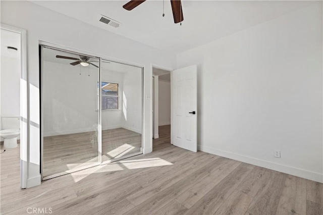 unfurnished bedroom featuring light hardwood / wood-style flooring, ceiling fan, and a closet