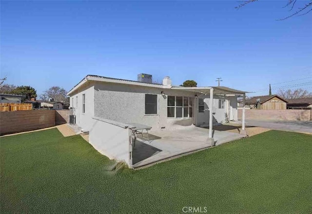 back of house featuring a lawn and a patio area