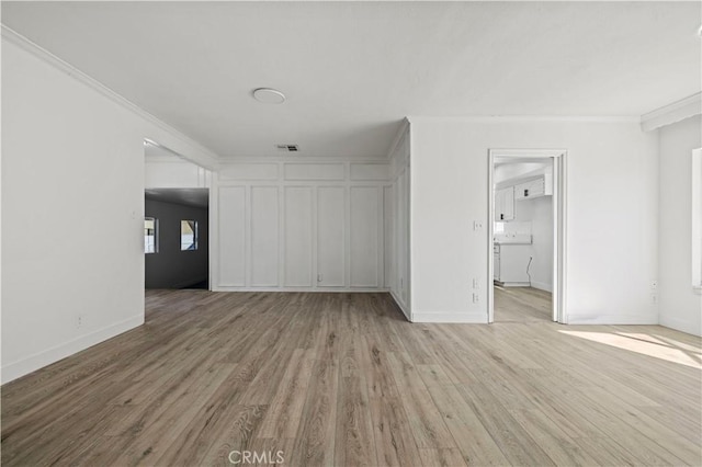 interior space with ornamental molding and light hardwood / wood-style floors