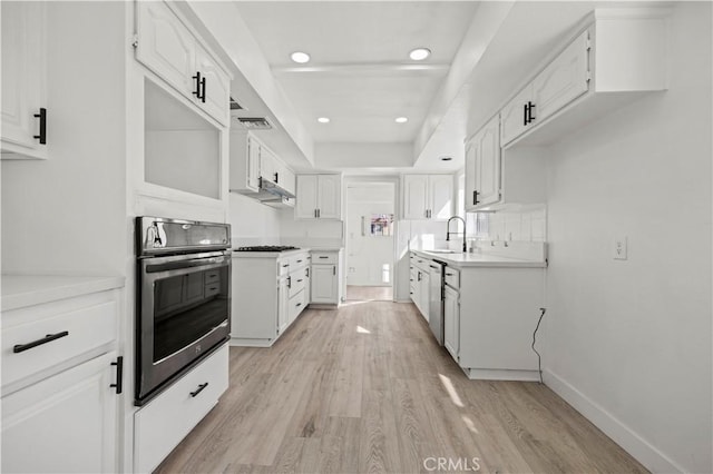 kitchen with sink, dishwasher, white cabinetry, oven, and light wood-type flooring