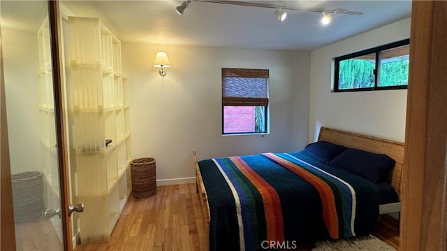 bedroom with light hardwood / wood-style floors and multiple windows