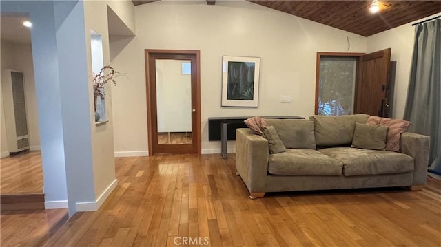 living room featuring vaulted ceiling, light hardwood / wood-style flooring, and wooden ceiling