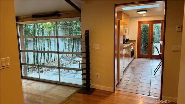 doorway with light hardwood / wood-style floors, a wealth of natural light, and french doors