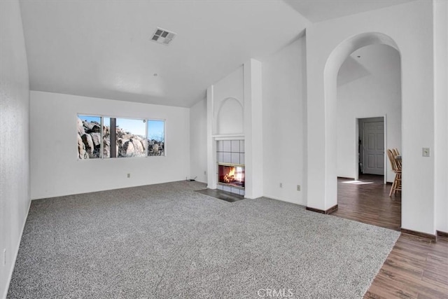 unfurnished living room with lofted ceiling and a fireplace