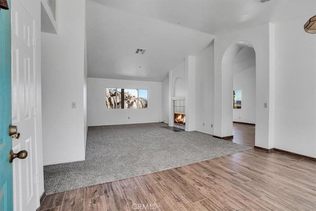 unfurnished living room with light hardwood / wood-style floors and lofted ceiling