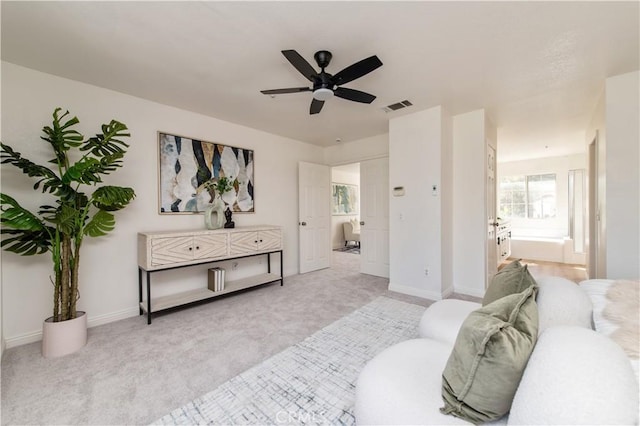 bedroom featuring ensuite bath, light colored carpet, and ceiling fan