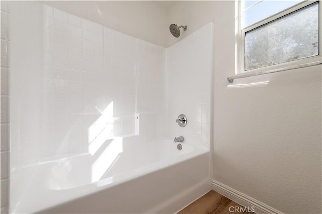 bathroom featuring hardwood / wood-style flooring and bathing tub / shower combination