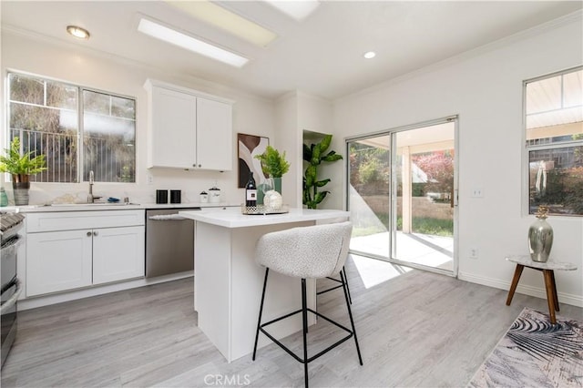 kitchen featuring a center island, stainless steel dishwasher, sink, light wood-type flooring, and white cabinets