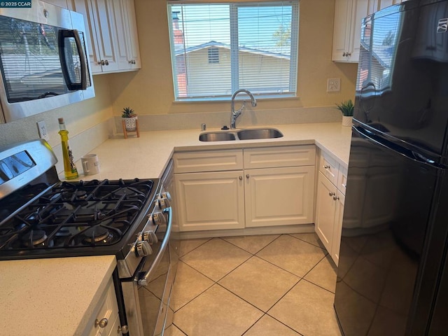 kitchen with white cabinetry, appliances with stainless steel finishes, sink, and light tile patterned floors