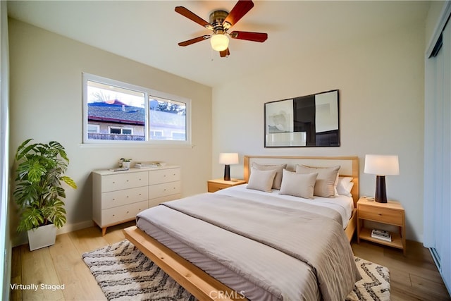 bedroom featuring light wood-type flooring, ceiling fan, and a closet