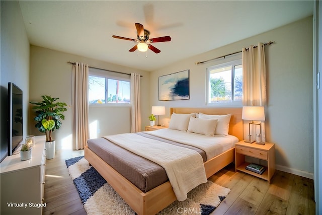 bedroom with ceiling fan and light hardwood / wood-style floors