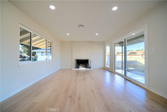 unfurnished living room with a fireplace and light hardwood / wood-style flooring