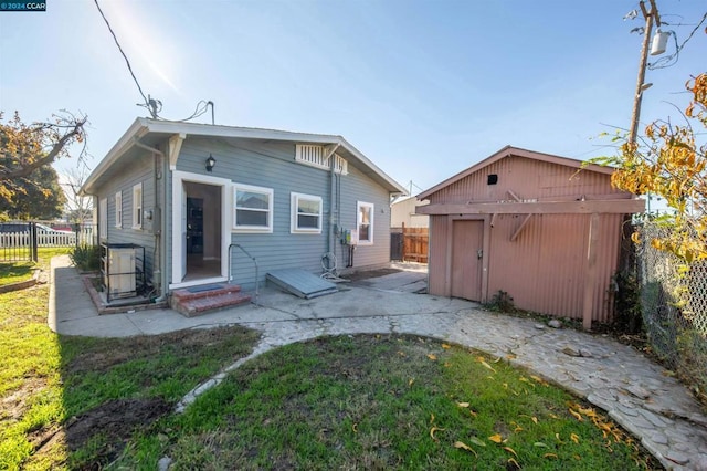 back of house featuring an outdoor structure and a yard