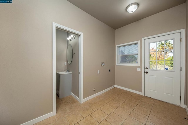 doorway with sink and light tile patterned floors