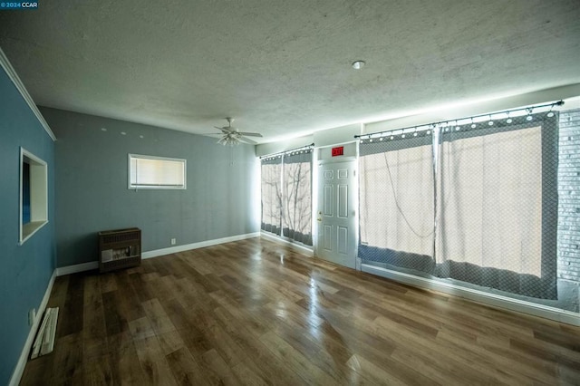 spare room with heating unit, ceiling fan, a textured ceiling, and wood-type flooring