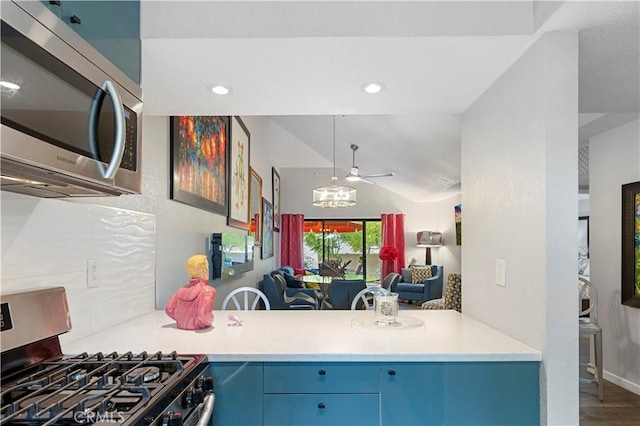 kitchen with lofted ceiling, recessed lighting, light countertops, appliances with stainless steel finishes, and wood finished floors