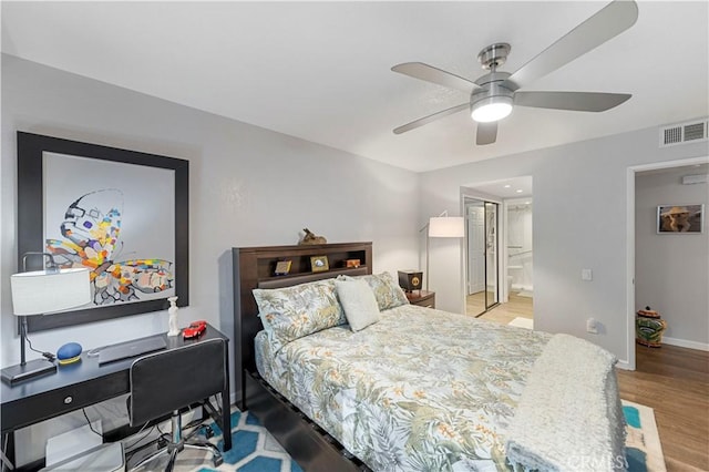 bedroom with ensuite bathroom, light wood-style flooring, a ceiling fan, visible vents, and baseboards