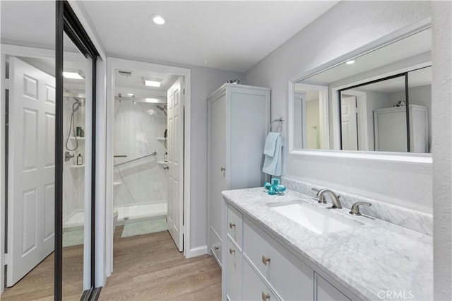 bathroom featuring recessed lighting, wood finished floors, visible vents, vanity, and a stall shower