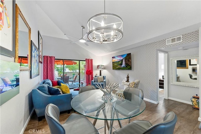 dining room with an accent wall, wood finished floors, visible vents, baseboards, and wallpapered walls