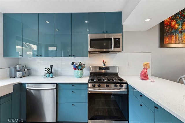 kitchen with appliances with stainless steel finishes, backsplash, blue cabinetry, and modern cabinets