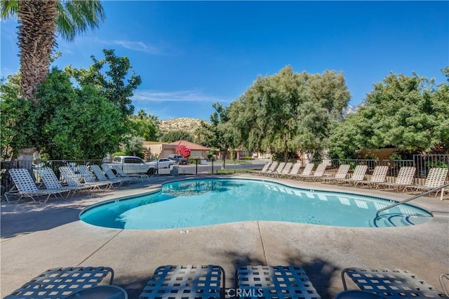 pool with a patio area and fence