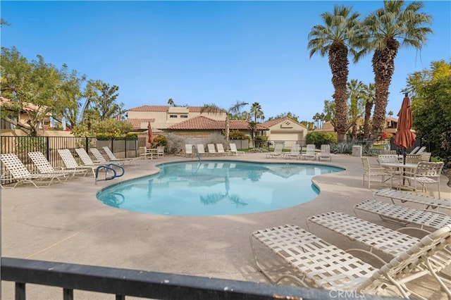 pool featuring fence and a patio