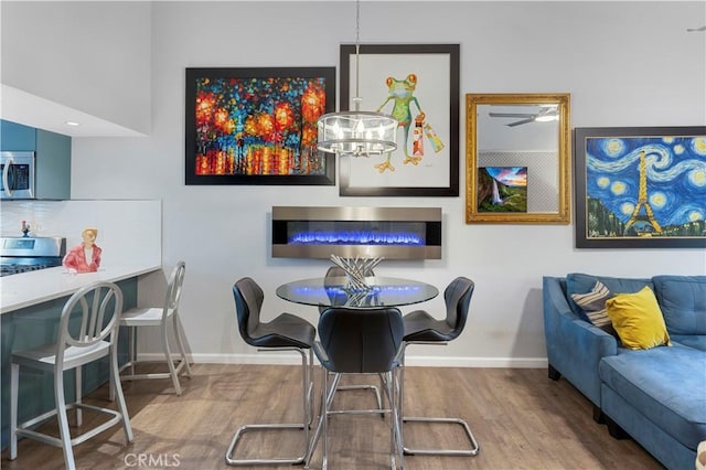 dining room featuring baseboards, a chandelier, and wood finished floors