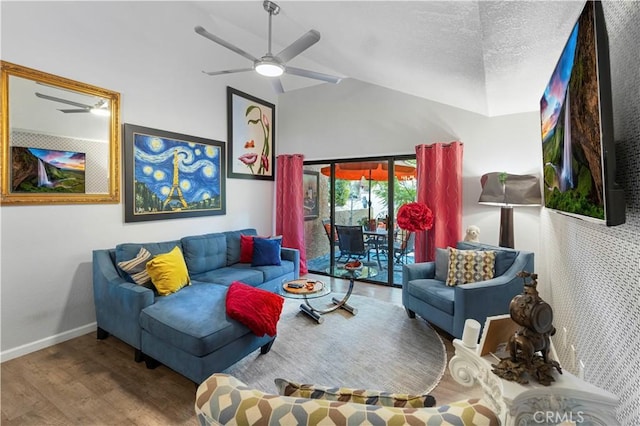 living area with a ceiling fan, vaulted ceiling, a textured ceiling, wood finished floors, and baseboards