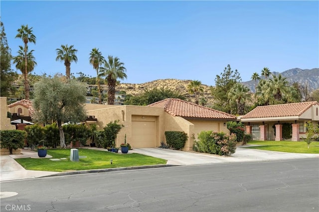 view of front of property with stucco siding, a mountain view, a garage, driveway, and a tiled roof