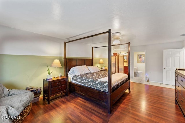 bedroom with ceiling fan, wood-type flooring, and connected bathroom