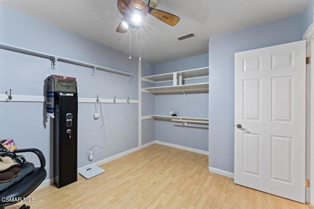 walk in closet featuring light hardwood / wood-style floors and ceiling fan