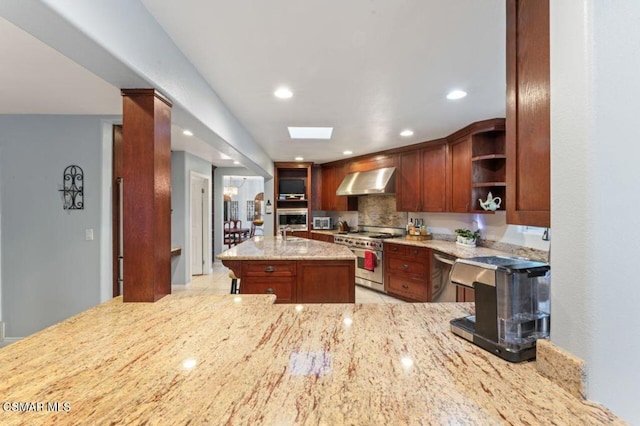 kitchen featuring kitchen peninsula, appliances with stainless steel finishes, decorative backsplash, wall chimney range hood, and light stone counters