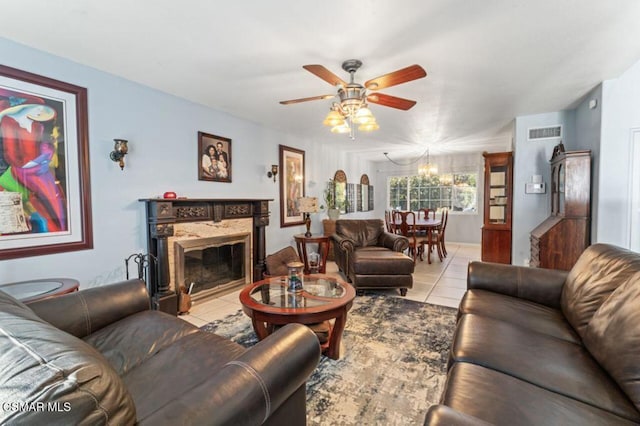 tiled living room with ceiling fan with notable chandelier