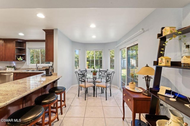 dining area featuring sink and light tile patterned floors