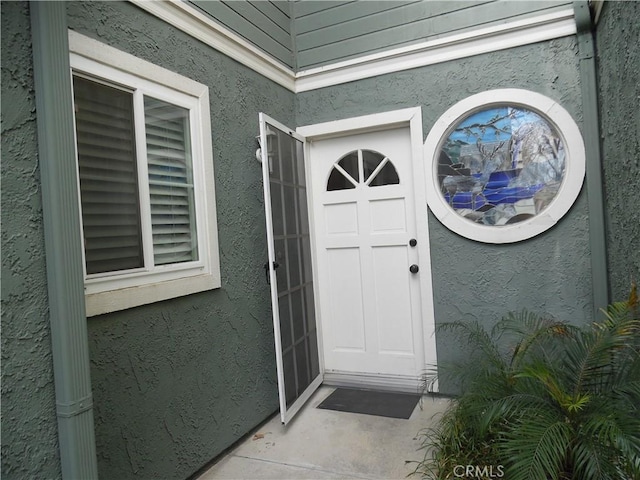 entrance to property featuring stucco siding