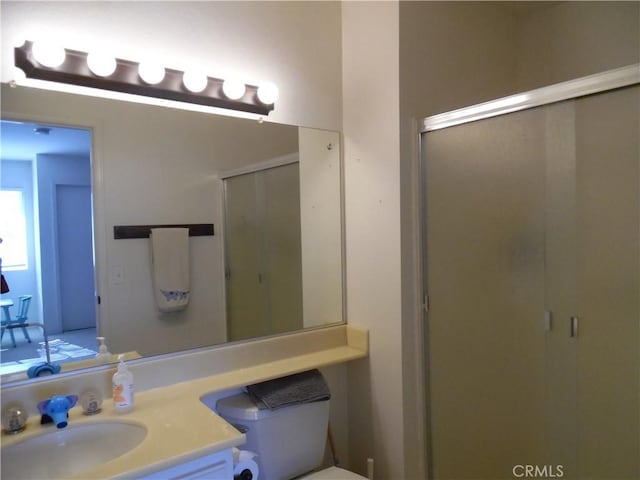 bathroom with vanity, an enclosed shower, and toilet