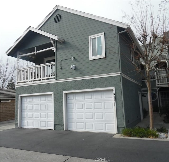 view of front of house featuring a garage and a balcony