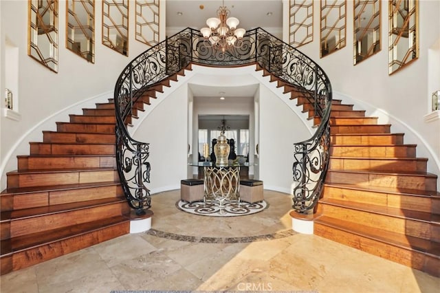 entryway with a towering ceiling and a notable chandelier