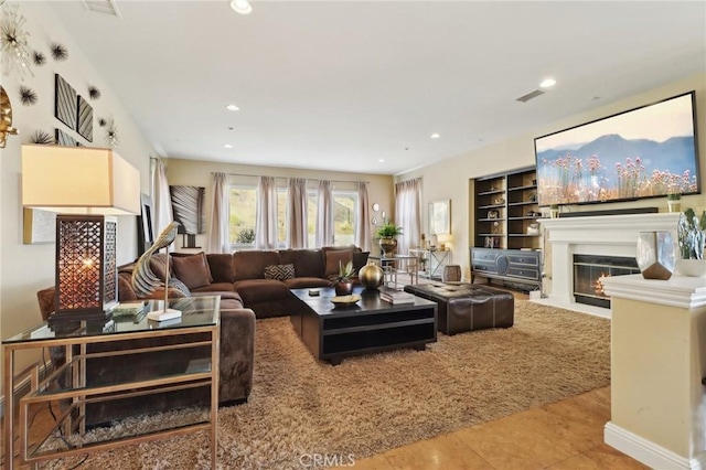 living room featuring a fireplace with flush hearth, visible vents, tile patterned flooring, and recessed lighting