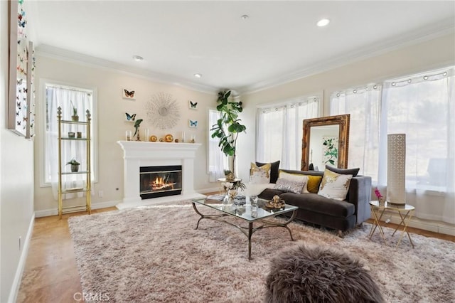 living area with recessed lighting, baseboards, ornamental molding, and a glass covered fireplace