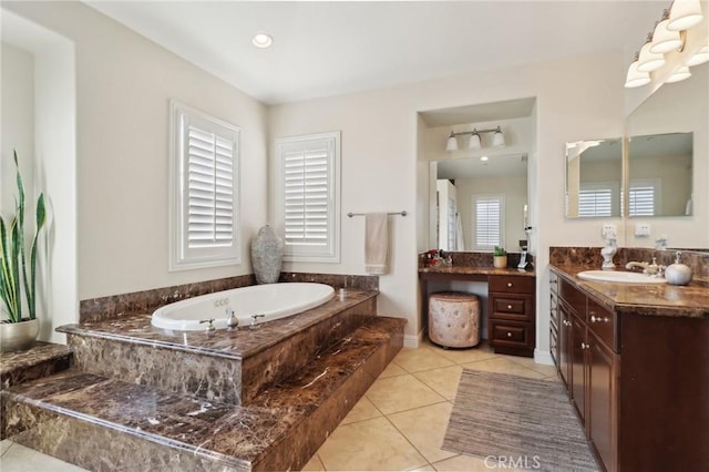 bathroom featuring tile patterned flooring, vanity, and a relaxing tiled tub