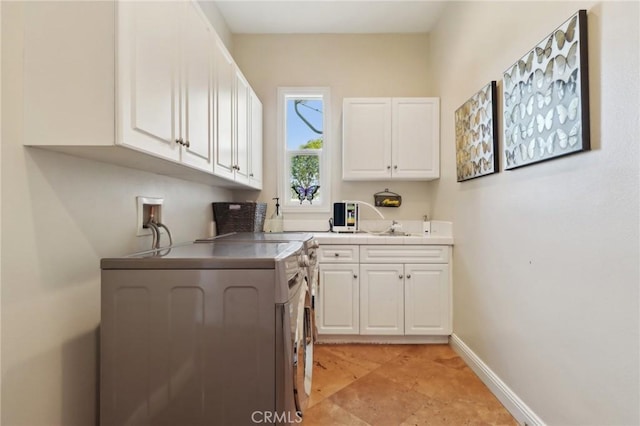 kitchen featuring washer / dryer, sink, and white cabinets