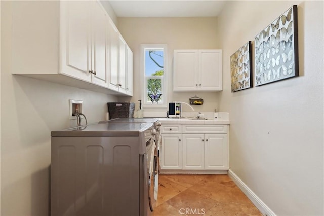 interior space featuring a sink, white cabinetry, and baseboards