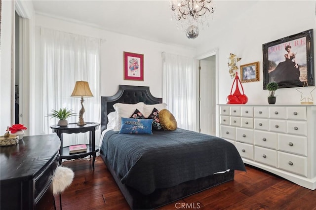 bedroom with a notable chandelier and dark wood-type flooring