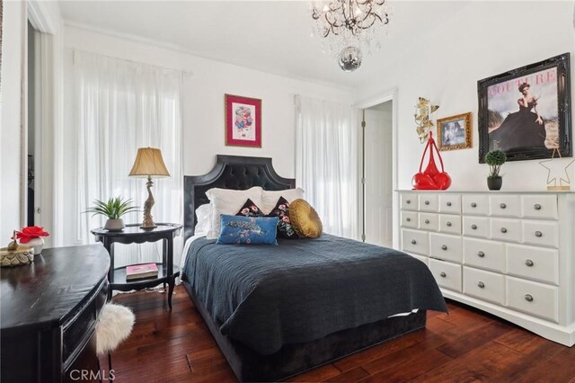 bedroom featuring a notable chandelier, multiple windows, and dark wood-type flooring