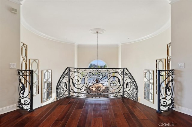 hallway with ornamental molding, wood finished floors, an upstairs landing, and baseboards