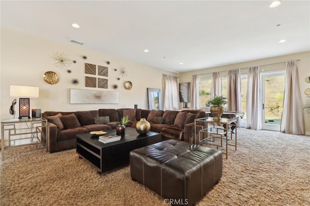 carpeted living area with visible vents and recessed lighting